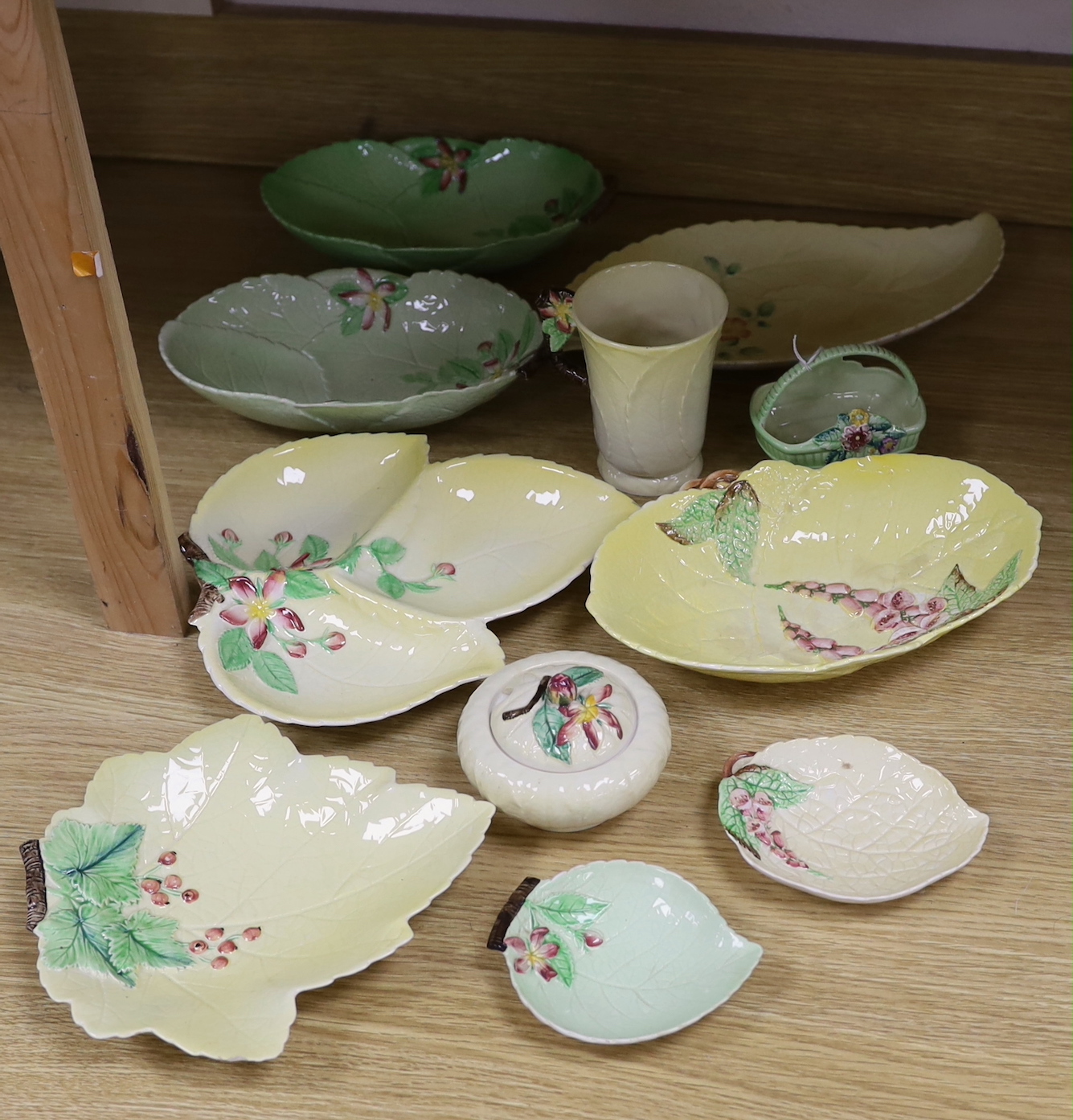 A collection of Carlton Ware leaf moulded dishes, a cup and a preserve pot and cover